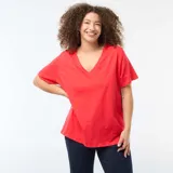 Camiseta básica de manga corta con cuello en pico, confeccionada en algodón, de corte holgado y diseño liso.