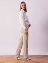 Pantalón de vestir color beige, de corte recto, con bolsillos laterales y traseros. Se ajusta a la cintura con broches internos y cierre.