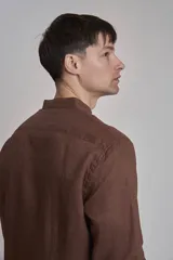 Camisa de lino color marrón, con cuello mao, manga larga y botones blancos.