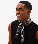 Pañuelo cuadrado de poliéster con estampa paisley en tonos oscuros y blancos, de caída ligera y diseño versátil.