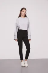 Calza negra de tiro alto con cierre lateral y detalle de costura en la rodilla.