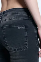 Jean de corte oxford confeccionado en denim de algodón con un toque de elastano. Presenta un lavado localizado en tono gris oscuro, tiro bajo y cierre frontal con botón y cremallera. Incluye avíos personalizados de la marca.