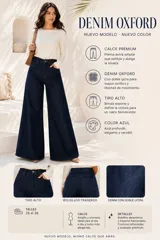 Jeans oxford de mezclilla azul oscuro, tiro alto, con bolsillos laterales y traseros, y perneras amplias y acampanadas.