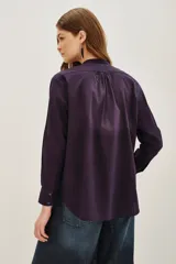 Camisa de algodón color blanco, con cuello redondo, cierre frontal parcial con botones y detalle de bordado con canutillos en el frente.