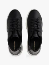 Zapatillas de plataforma Tommy Hilfiger, color negro con suela blanca. Presentan un diseño de corte bajo con cordones, confeccionadas en cuero y material sintético, con el monograma TH en el lateral y detalles metálicos en el talón.