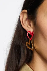 Caravanas con diseño de dos corazones entrelazados de textura irregular. Presentan un acabado bicolor en tonos dorado y plateado.