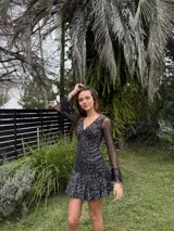 Vestido corto de encaje marrón, con escote en V, corte debajo del busto, mangas largas estilo trompeta y espalda transparente con volado en el ruedo.