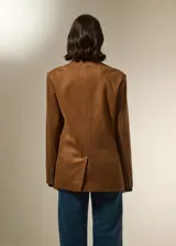 Blazer de gamuza color marrón, con cuello solapa, cierre frontal con un botón, bolsillos frontales tipo parche y diseño holgado.