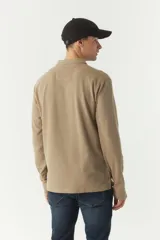 Polo de manga larga color beige con textura, fit regular, logo estampado y puños.