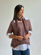 Sweater de punto color marrón chocolate con cuello redondo, mangas tres cuartos y diseño asimétrico. Incluye un pañuelo a juego con detalles de puntilla en los bordes.