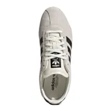 Championes Adidas modelo Tokyo, de diseño retro y perfil bajo. Confeccionados en gamuza color beige con las icónicas tres tiras laterales en cuero negro, forro interno de cuero y suela de caucho color caramelo.
