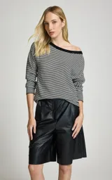 Blusa de punto a rayas horizontales en blanco y negro, con escote barco caídas de hombro y mangas largas.