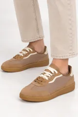 Zapatilla deportiva estilo urbano de corte bajo, color verde con suela de goma marrón y cordones oscuros.