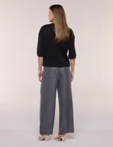 Buzo de calce relajado color negro, confeccionado en modal con cuello redondo clásico, mangas tres cuartos de hombros caídos con puño y ruedo recto.