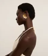 Aros caravana medianos de metal dorado con diseño de flor de pétalos arrugados y centro texturizado.