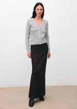 Cardigan de punto trenzado en color gris, con cuello en pico, manga larga y cierre frontal con botones.