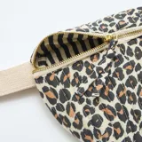 Riñonera de diseño acolchado con estampado animal print de leopardo, cierre superior con cremallera metálica y correa ajustable de lona en color crudo.