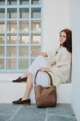 Cartera tipo bolso con diseño de animal print de leopardo, confeccionada en cuero. Presenta una correa de hombro fija con herrajes metálicos en tono bronce y un compartimento principal espacioso.