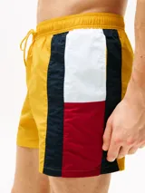 Short de baño amarillo con cintura elástica ajustable con cordón. Presenta una banda vertical en el lateral con los colores blanco, azul marino y rojo.