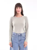 Remera verde con cuello redondo y mangas largas, con detalle de pequeñas tachas plateadas alrededor del cuello.