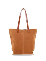 Cartera tote de gamuza color marrón maíz, con asas largas de cuero liso en tono tostado y placa con el logo de la marca en el frente.