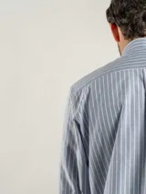 Camisa de corte regular confeccionada en tejido Oxford de algodón, con diseño de rayas verticales finas. Presenta cuello abotonado, cierre frontal con botones y un bolsillo en el pecho.