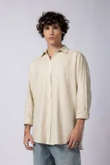 Camisa de manga larga confeccionada en lino, de corte holgado y diseño minimalista con cuello clásico y cierre frontal de botones.