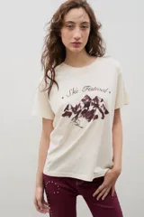Remera de algodón color crema con cuello redondo, mangas cortas y estampa frontal en color bordó con diseño de montañas y texto Ski Festival.