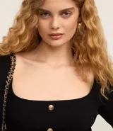 Blusa cropped de punto roja con escote cuadrado, mangas largas y botones dorados.