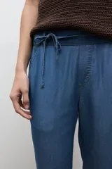 Pantalón de corte recto confeccionado en lyocell, color azul jean medio, con cintura elástica con cordón de ajuste y bolsillos laterales.