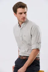 Camisa lisa de manga larga de algodón en color gris claro, de corte slim fit con cuello camisero y cierre frontal de botones.