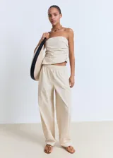 Pantalón largo color beige de tiro medio, con cintura elástica y bolsillos laterales.