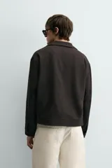 Sobrecamisa regular fit color gris oscuro, confeccionada en tejido con viscosa. Presenta cuello solapa, manga larga con puño abotonado, bolsillos de vivo en la cadera y cierre frontal con cremallera.