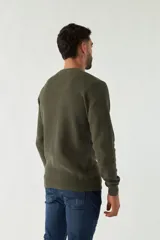 Sweater azul marino de punto con cuello redondo, mangas largas y logo bordado en el pecho.