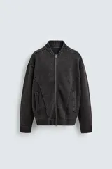 Chaqueta tipo bomber de punto compacto en algodón, con efecto lavado, cuello subido, cierre frontal con cremallera, bolsillos laterales de vivo y acabados en rib.