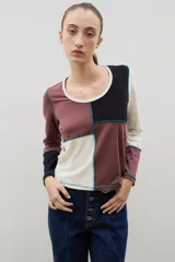 Remera de manga larga con diseño de bloques de color en tonos neutros, confeccionada con costuras externas visibles en color azul contrastante.