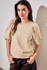Remera de algodón negro con mangas cortas abullonadas, cuello redondo y costura central frontal.