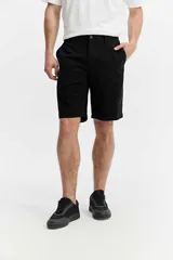 Bermuda de cinco bolsillos color negro con líneas rectas y estructura relajada.
