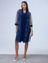 Conjunto de fiesta RM Richards compuesto por vestido azul de seda fría con escote redondo y aplique de microtul bordado, y chaqueta de microtul bordado con mangas tres cuartos y forro interno a tono.