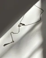 Collar tipo gargantilla en Y, diseñado y elaborado a mano en plata, con cadena rolo, dije en forma de gota con perla de río y aro metálico entrelazado.
