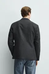 Blazer regular fit de bouclé con diseño pata de gallo en tonos oscuros, solapas de muesca, cierre de un botón y bolsillos con solapa en la cadera.