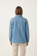 Campera de denim de corte largo, color crudo con costuras en contraste de color marrón, múltiples bolsillos frontales y botones oscuros.
