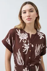 Vestido midi marrón con estampado floral blanco, cuello mao, manga corta y lazo ajustable en la cintura.