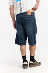 Bermuda de jean estilo baggy, color azul oscuro, con silueta amplia y largo por debajo de la rodilla, confeccionada en 100% algodón.