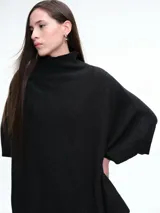 Poncho amplio de cuello alto, confeccionado en hilado con lana y cashmere, con diseño de caída recta y botones laterales.