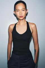 Top de cuello halter con diseño ajustado y escote con costuras tipo corset en el busto. Presenta espalda descubierta y bajo recto.