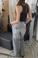 Pantalón de jean recto de tiro medio color gris oscuro con costuras verticales.