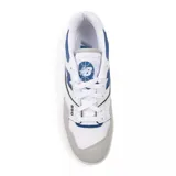 Championes urbanos New Balance modelo 550, con diseño retro inspirado en el básquet de los años 80. Presentan una combinación de cuero sintético blanco, detalles en azul y gris, y suela de caucho color caramelo.