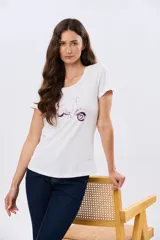 Remera blanca de manga corta y cuello redondo, con estampa frontal de una motoneta rosa estilo vintage con flores.