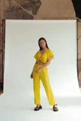 Pantalón amarillo de lino con bordados florales a lo largo de las piernas. El pantalón es de corte recto y tiro alto.